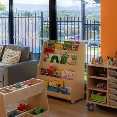 Picture books displayed face-out on a low timber shelf in the reading corner